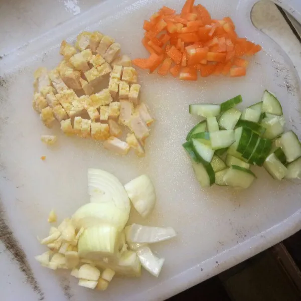 Cuci bersih timun, dan wortel. Kemudian iris dadu nugget, timun, dan wortel .Cincang halus bawang putih dan bawang bombay.