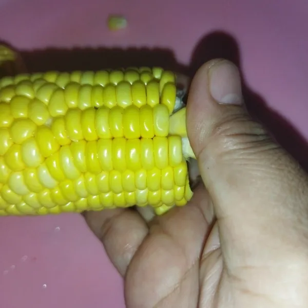 Mulai memipil jagung dari sisi potongan, pipil jadung dengan menggunakan bagian bawah ibu jari.