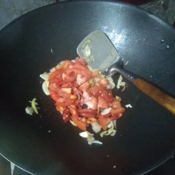 Masukkan tomat dan irisan cabai, aduk-aduk hingga layu.
