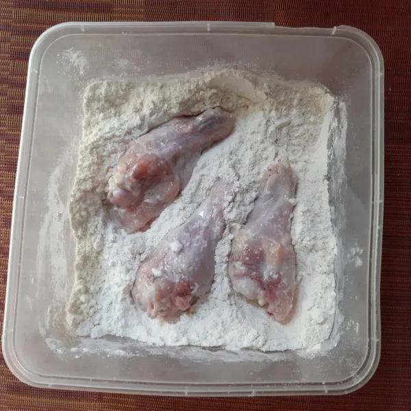 Tiriskan ayam dari rendaman. Pindahkan ke wadah berisi maizena dan kocok hingga seluruh ayam tertutup tepung.