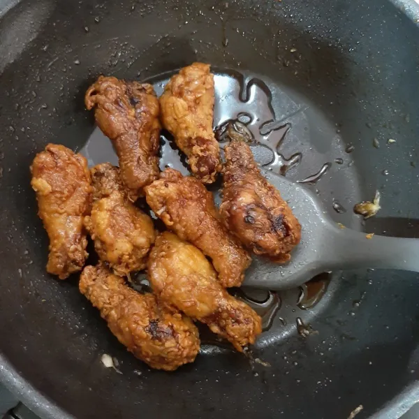 Masukkan ayam goreng ke dalam saus, aduk rata hingga semua permukaan terbalur saus. Taburi dengan wijen sangrai.