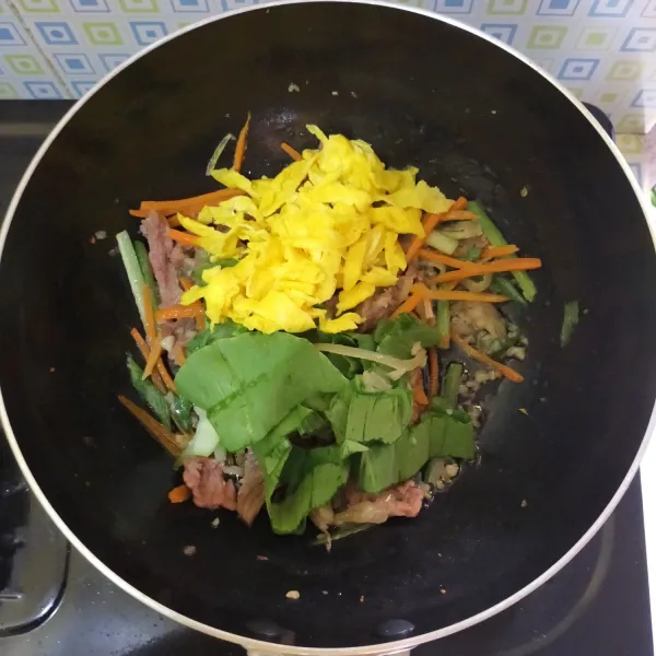 Sesaat sebelum di angkat, tambahkan daun pokcoy serta kuning telur. Aduk rata lalu matikan kompor.