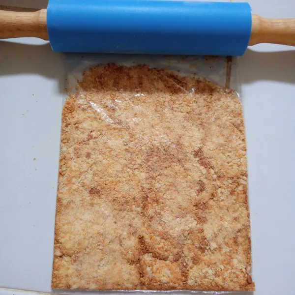 masukkan biskuit kedalam wadah kemudian remahkan menggunakan rolling pin.