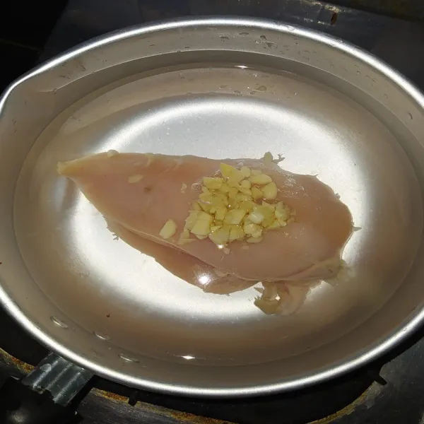 Rebus ayam bersama bawang putih cincang hingga matang