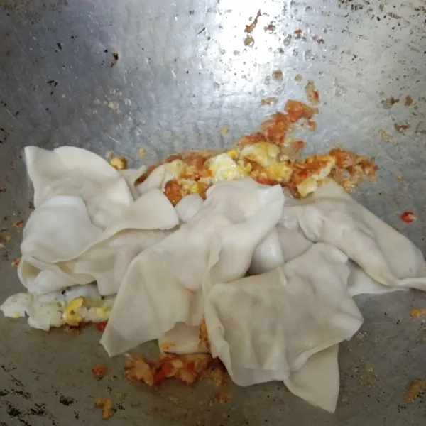 Masukan irisan telur goreng dan pangsit basah, aduk rata.