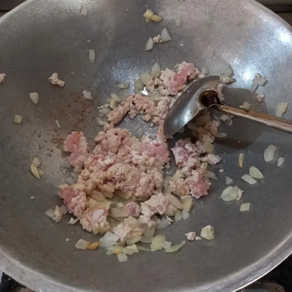 Tumis bawang bombay, bawang putih, dan daging ayam cincang sampai harum.