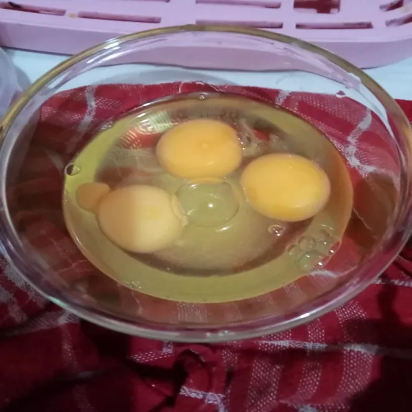 Pecahkan telur, lalu beri kaldu jamur, gula, dan lada bubuk, kocok lepas.