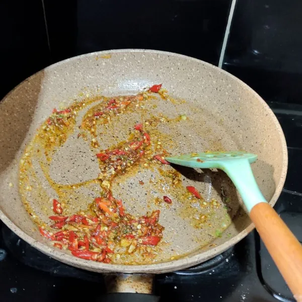Masukkan minyak lalu tambahkan gochugaru (cabe bubuk), cabe keriting, bawang putih, dan daun bawang. Aduk rata sampai harum.