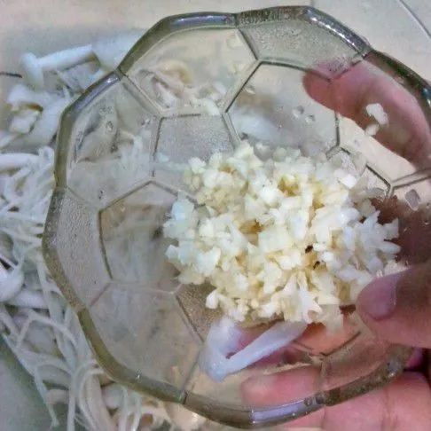 Campurkan jamur dengan bawang putih cincang, garam, dan minyak wijen.