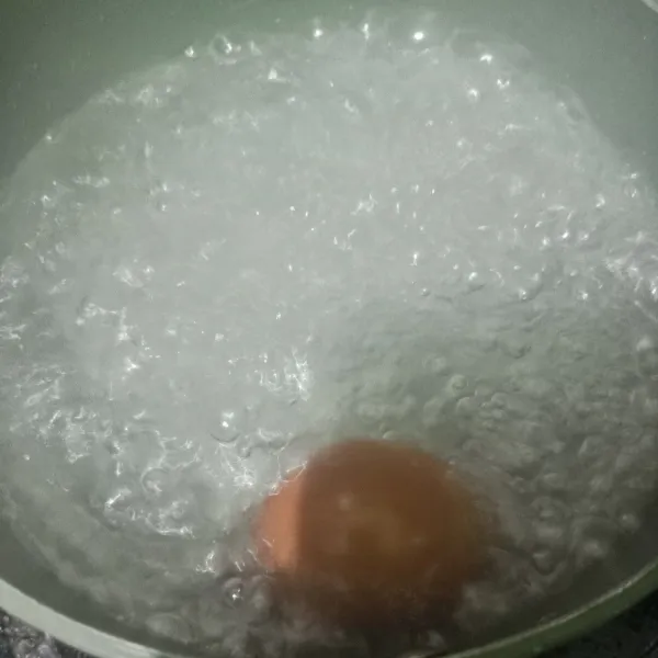 Siapkan panci lalu isi air. Tunggu mendidih lalu masukkan telur. Rebus sampai matang. Lalu angkat dan kupas kulit telur rebus.