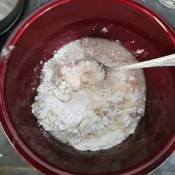 Larutkan ragi instan, air hangat, dan gula pasir, lalu masukan ke dalam tepung terigu, aduk hingga rata. Jika adonan masih terlalu kering, tambahkan air hangat secukupnya. Uleni hingga seluruh bahan tercampur rata dan adonan kalis.