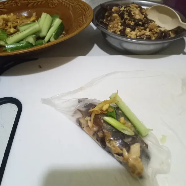 Bungkus oseng jamur dan ayam tadi dengan rice paper, ditambah dengan irisan timun, bawang bombai dan irisan daun bawang.