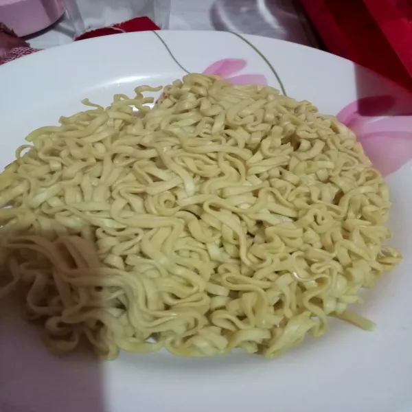 Rebus mie setengah matang, tambahkan beberapa tetes minyak goreng pada air rebusan agar mie tidak lengket saat diangkat, setelah terlihat agak lunak, angkat dan tiriskan.