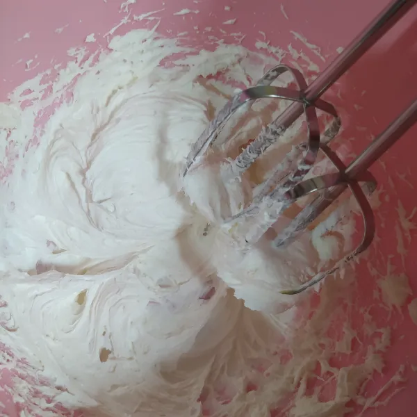Kocok whipped cream bubuk dengan air es hingga mengembang. Masukkan ke dalam kantong segitiga, potong ujungnya.