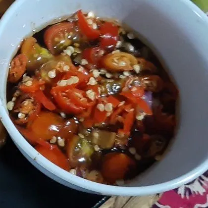 Sambil menunggu ayam meresap, buat sambal : iris tomat hijau, bawang merah dan cabe rawit. Masukkan ke dalam mangkuk sambal lalu siram dengan kecap manis.