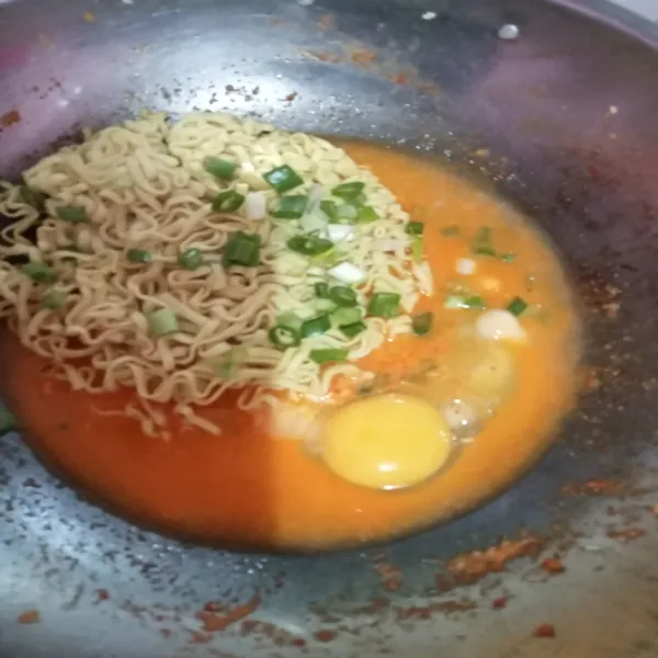 Tambahkan air, masukkan telur dan mie, beri potongan bawang daun.