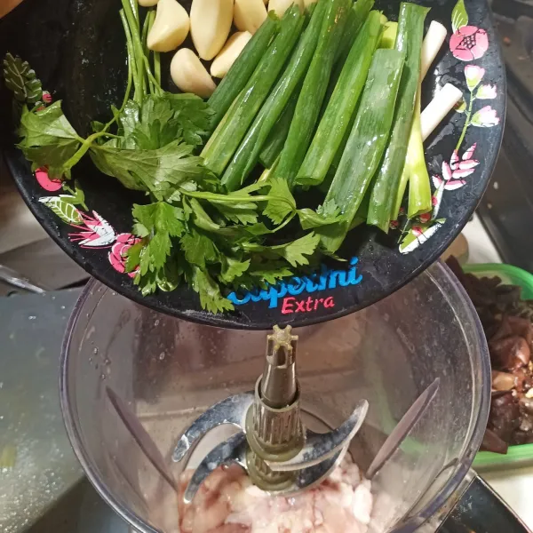 Masukkan kulit ayam, daun bawang, seledri dan bawang putih ke dalam penggiling. Giling sampai setengah halus.