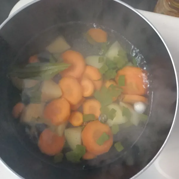 Masukkan wortel dan kentang, masak hingga lunak.