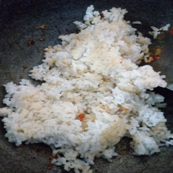 Masukkan nasi putih, aduk rata. Bumbui dengan garam dan kaldu bubuk. Koreksi rasa.
