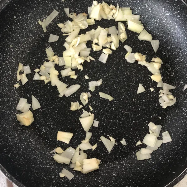 Tumis bawang bombay dan bawang putih hingga harum.