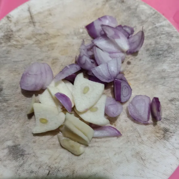Kupas bawang merah dan bawang putih lalu iris tipis-tipis.