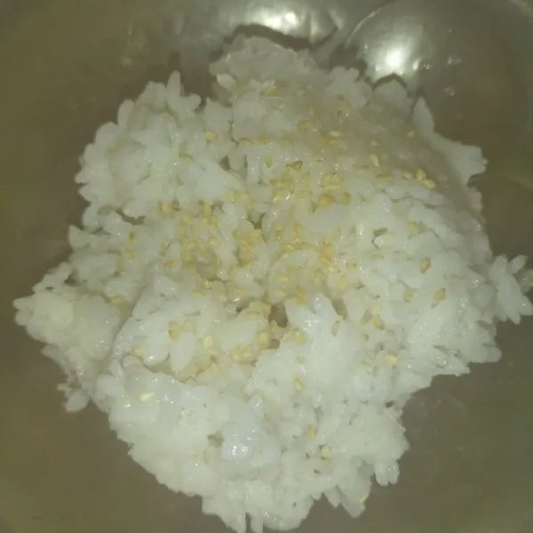Siapkan 1 centong nasi panas, beri 1 sdt minyak wijen, sedikit garam dan 1/4 sdt wijen sangrai, aduk rata. Ini 1 porsi nasi untuk 1 lembar noro, saya bikin per porsi agar nasi tidak cepat dingin.