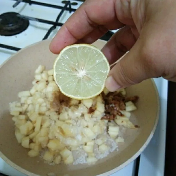 Siapkan wajan, tuang potongan apel, kemudian tambahkan garam, gula pasir, gula merah, kayu manis bubuk dan perasan air jeruk lemon.