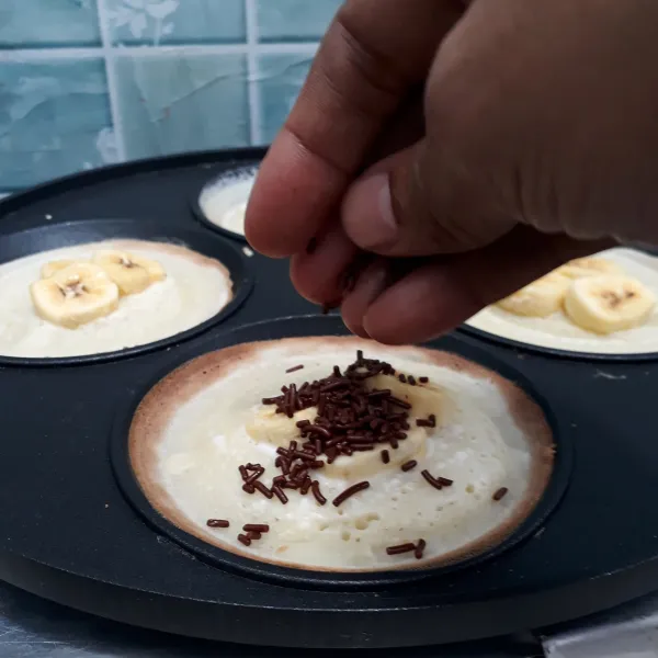 Taburi atasnya dengan meses coklat lalu angkat serabi dari cetakan.