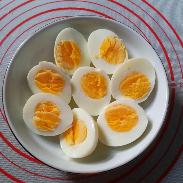 Rebus telur sampai cukup matang. Kupas dan belah dua.