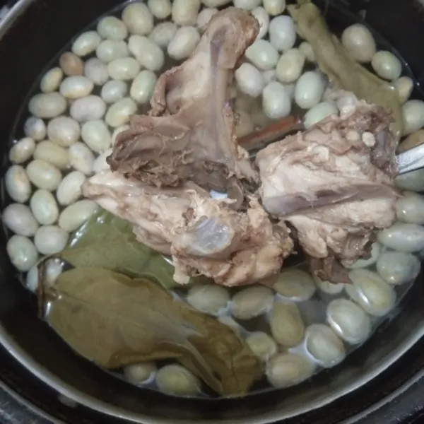 Masukkan juga tulang ayam yang telah direbus, masak hingga kacang empuk.