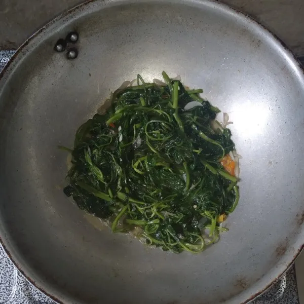 Tambahkan sedikit air, masukkan saus tiram, dan penyedap rasa, koreksi rasa. Masak hingga kangkung empuk.