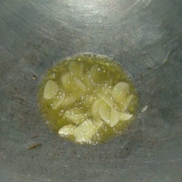 Tumis irisan bawang putih hingga harum.