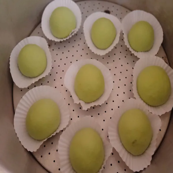 Jika bakpao sudah mulai mengembang. Saatnya panaskan air untuk mengukus bakpao. Ini salah satu trik agar bakpao mulus. Air untuk mengukus jangan terlalu banyak yah, agar uap tidak menjiprat ke bakpao yang bisa membuat bakpao kisut. Panaskan air  hingga panas dan beruap banyak. Kukus bakpao dg api sedang. Selama 12 menit saja jangan lebih, bila perlu set Alarm. Jangan lupa lapisi tutup kukusan dengan kain bersih, agar air tidak menetes ke bakpao. Setelah 12 menit. Matikan api. Trik berikutnya, tutup kukusan jangan langsung dibuka, diamkan dulu 1 menit. Lalu renggangkan tutup kukusan sedikit. Biarkan uap panasnya keluar dulu baru boleh dibuka yah. Step ini penting agar mendapatkan bakpao yang mulus.