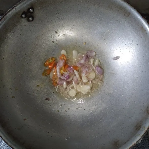 Tumis bawang merah, bawang putih, cabe rawit dengan minyak bekas menggoreng teri hingga harum.