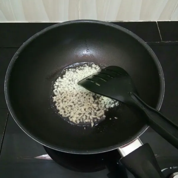 Panaskan minyak goreng, tumis bawang putih cincang hingga harum.