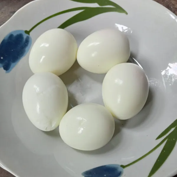 Rebus telur hingga matang dan kupas kulitnya.