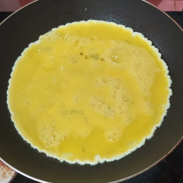 Kocok telur, tuang ke dalam pan atau wajan yang sudah dipanaskan dan diberi minyak goreng.