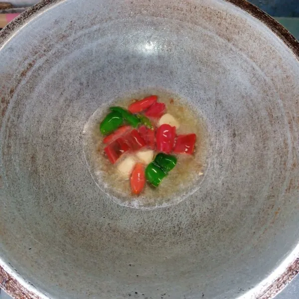 Siapkan sambal dengan goreng bawang putih, cabai merah besar, cabai hijau besar, dan cabai rawit sampai layu.