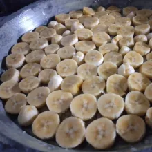 Olesi cetakan dengan margarin. Taburi gula. Potong-potong pisang sesuai selera, lalu tata di cetakan.