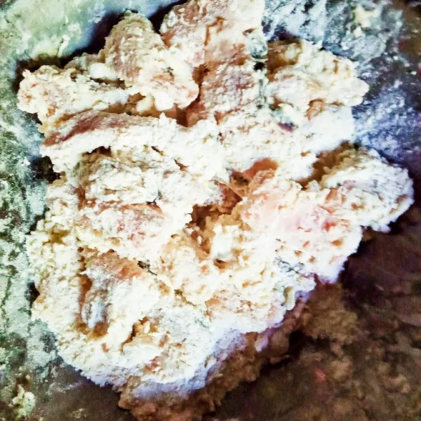 Masukkan tepung terigu dan maizena. Aduk rata sambil diremas-remas supaya bumbu dan tepung menempel sempurna.