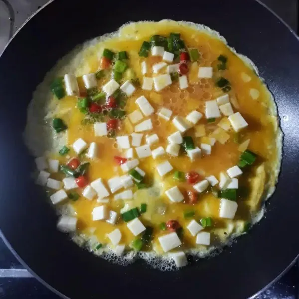 Panaskan minyak, goreng omelet menggunakan api sedang sampai sisi bawah matang dan kokoh.