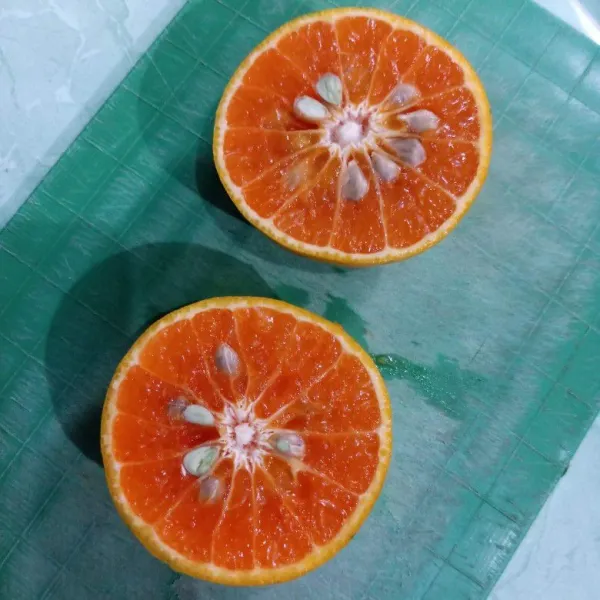 Belah jeruk jadi dua bagian.