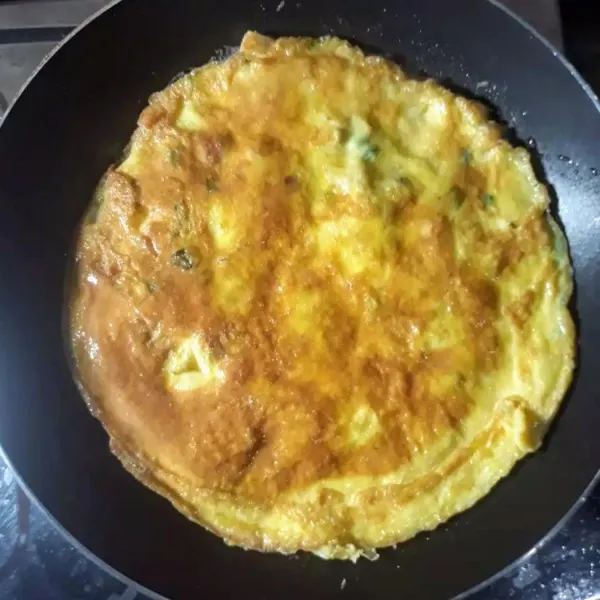 Balik omelet, masak sebentar sampai kedua sisi matang sempurna. Angkat lalu sajikan.