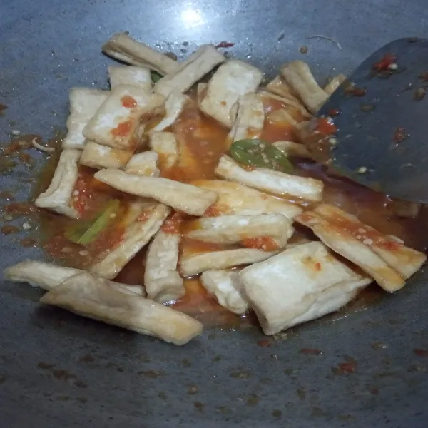 Tambahkan sedikit air, masukkan tahu. Aduk rata. Masak hingga bumbu meresap kedalam tahu. Sajikan.