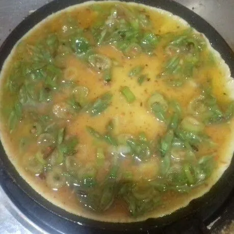 Panaskan pan teflon dengan sedikit minyak. Tuang telur buncis. Masak hingga matang kedua sisinya.