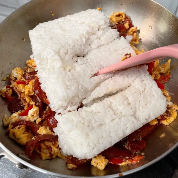 Masukkan nasi putih, dan tambahkan garam, kaldu jamur, kecap manis dan saos tiram, aduk sampai merata.
