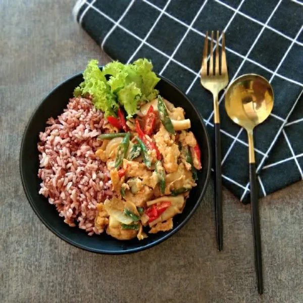 Siapkan nasi di mangkuk, tuang orak arik dimsum, beri hiasan daun selada.