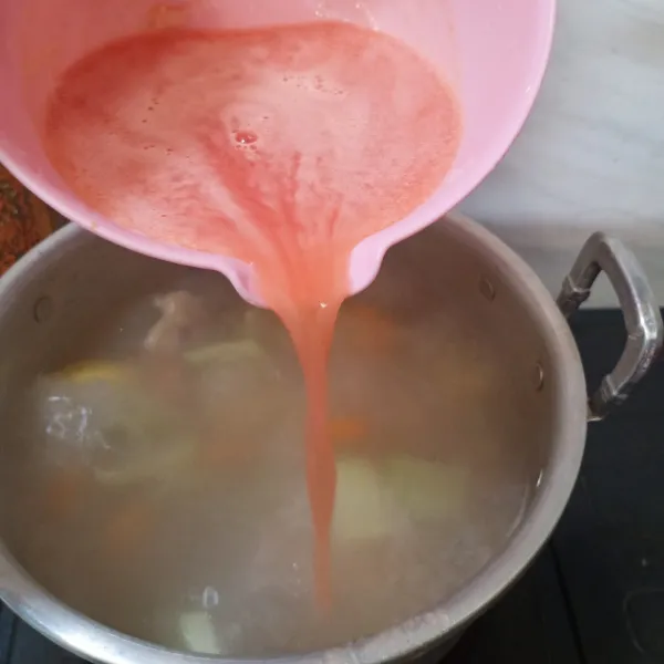 Tuangkan air tomat ke dalam sup.