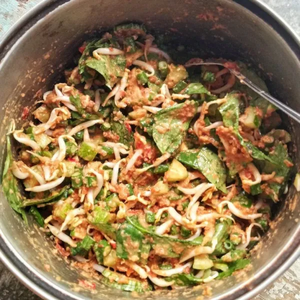 Pindahkan sayuran dalam wadah besar, tambahkan bumbu kacang, aduk rata.