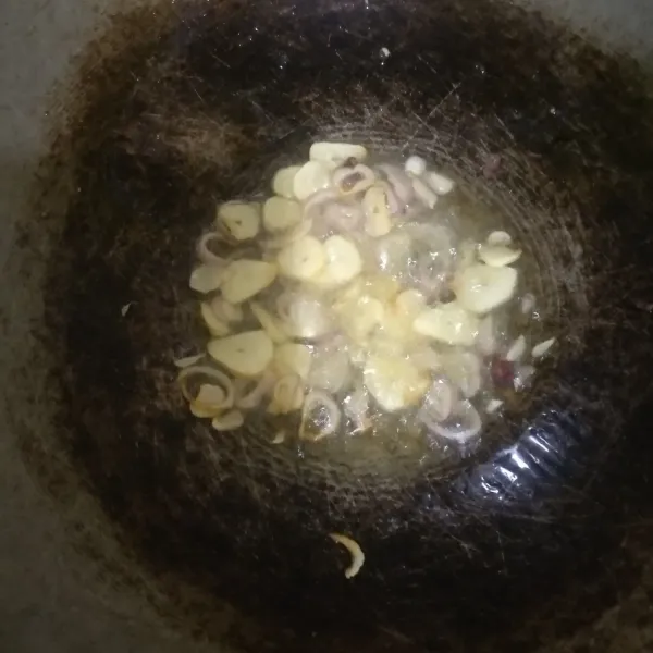 Tumis bawang dengan minyak panas sampai layu.